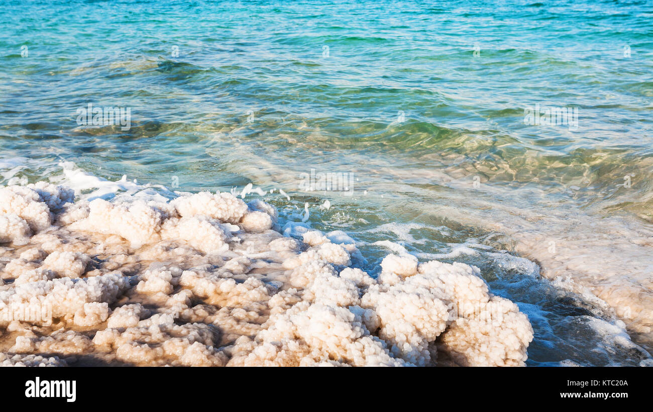 salt crystals on shore of Dead Sea in sunny day Stock Photo