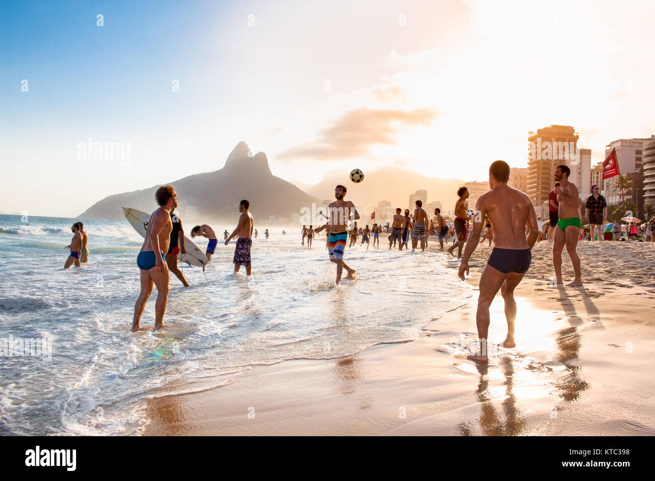 RIO DE JANEIRO, BRAZIL - APRIL 24, 2015: Carioca Brazilians playing altinho futebol beach football kicking soccer balls at sunset Ipanema Beach on Apr Stock Photo