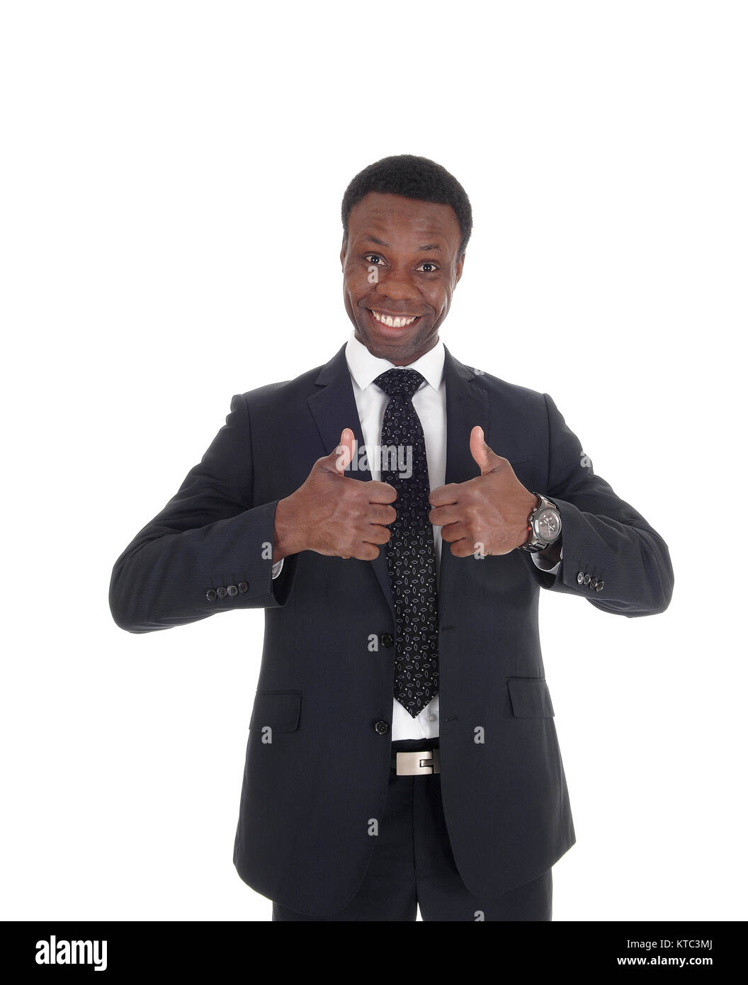A close up image of a smiling African businessman sign thumps up  standing  in a dark suit, isolated for white background Stock Photo