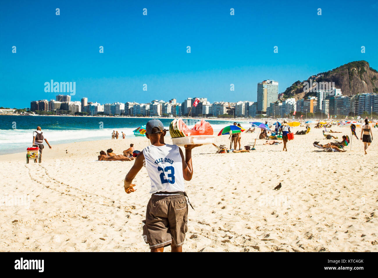 RIO DE JANEIRO, BRAZIL - APRIL 28, 2015: Old Brazilian carrying watermelon on April 28, 2015 at Copacabana Beach, Rio de Janeiro. Brazil. Stock Photo