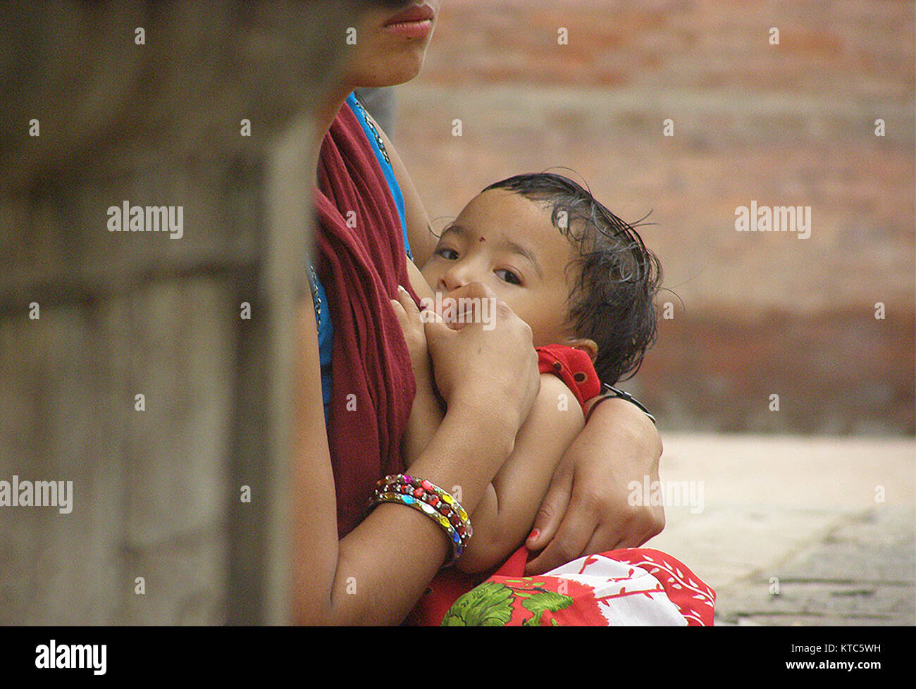 Nepal has made remarkable strides in improving the maternal health. A woman breastfeeding her child at the Basantapur Durbar square Kathmandu, Nepal. Stock Photo