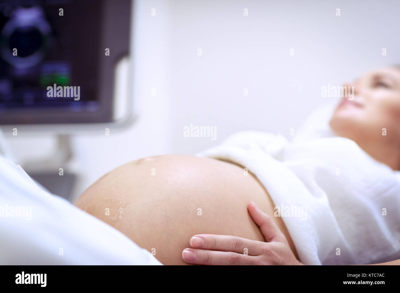 Pregnant woman doing ultrasound scanning in the prenatal clinic, mother ...