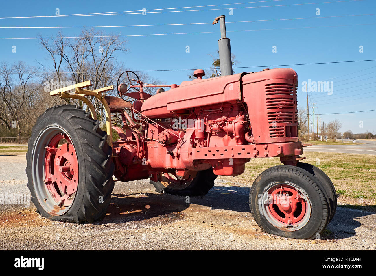 Old vintage red 1950's International Harvester, IH, farm tractor, unrestored, as a roadside display in Cecil Alabama, USA. Stock Photo