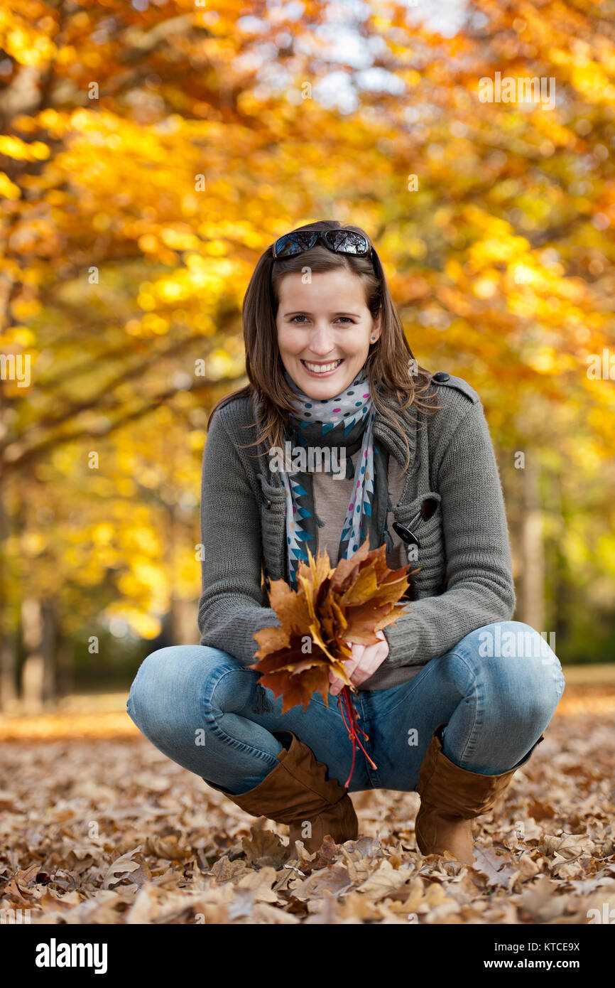 Young woman with autumn leaves in hand Stock Photo - Alamy