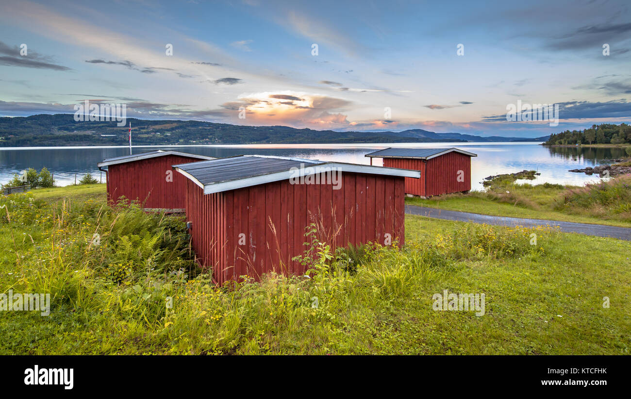 Idyllic red wooden cabins overseeing lake Mjosa near Lillehammer, Norway. Stock Photo