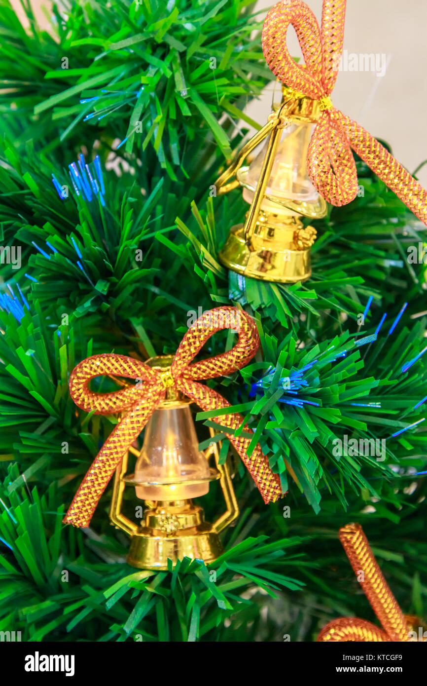 Golden Christmas tree bells and lanterns with bows on an artificial ...