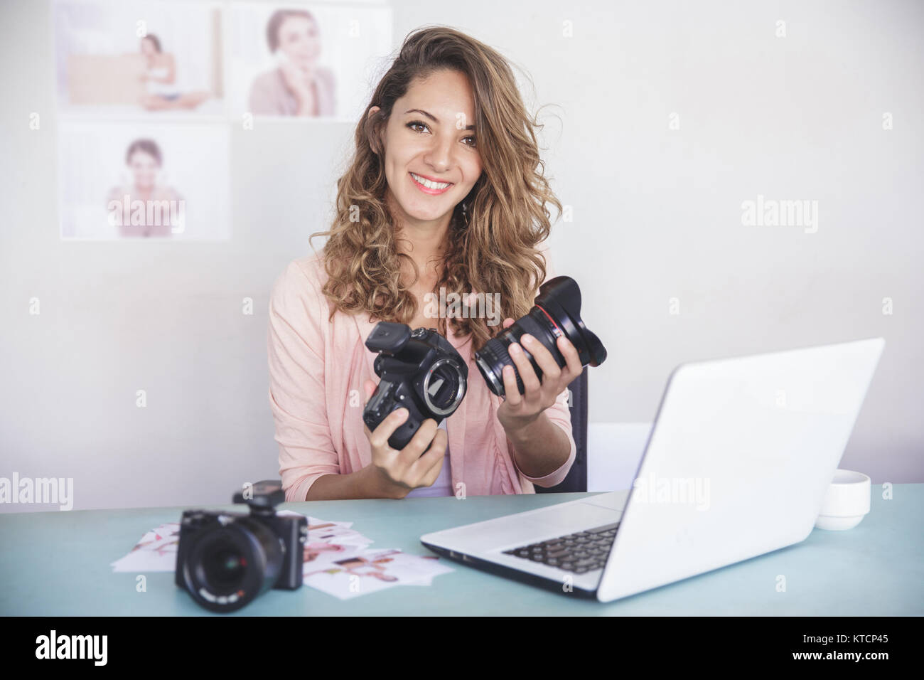young female photographer attaching the camera lens to camera bo Stock