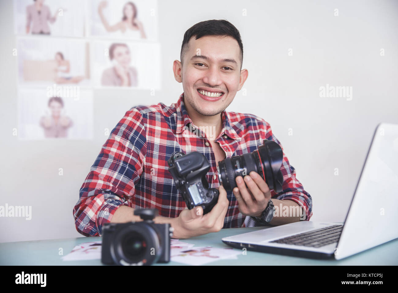 young photographer attaching the camera lens to camera body Stock Photo