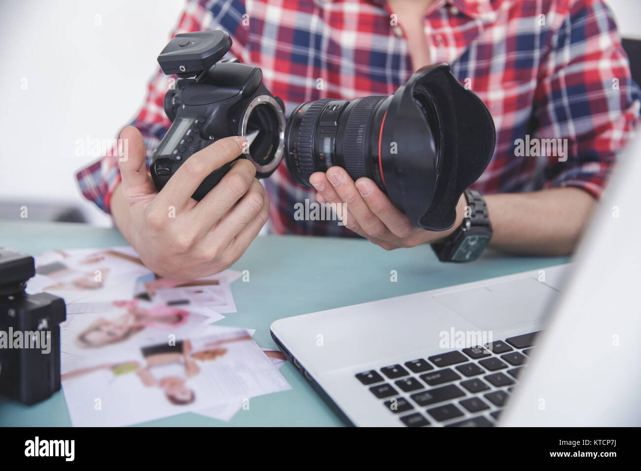 hands of photographer attaching the camera lens to camera body Stock