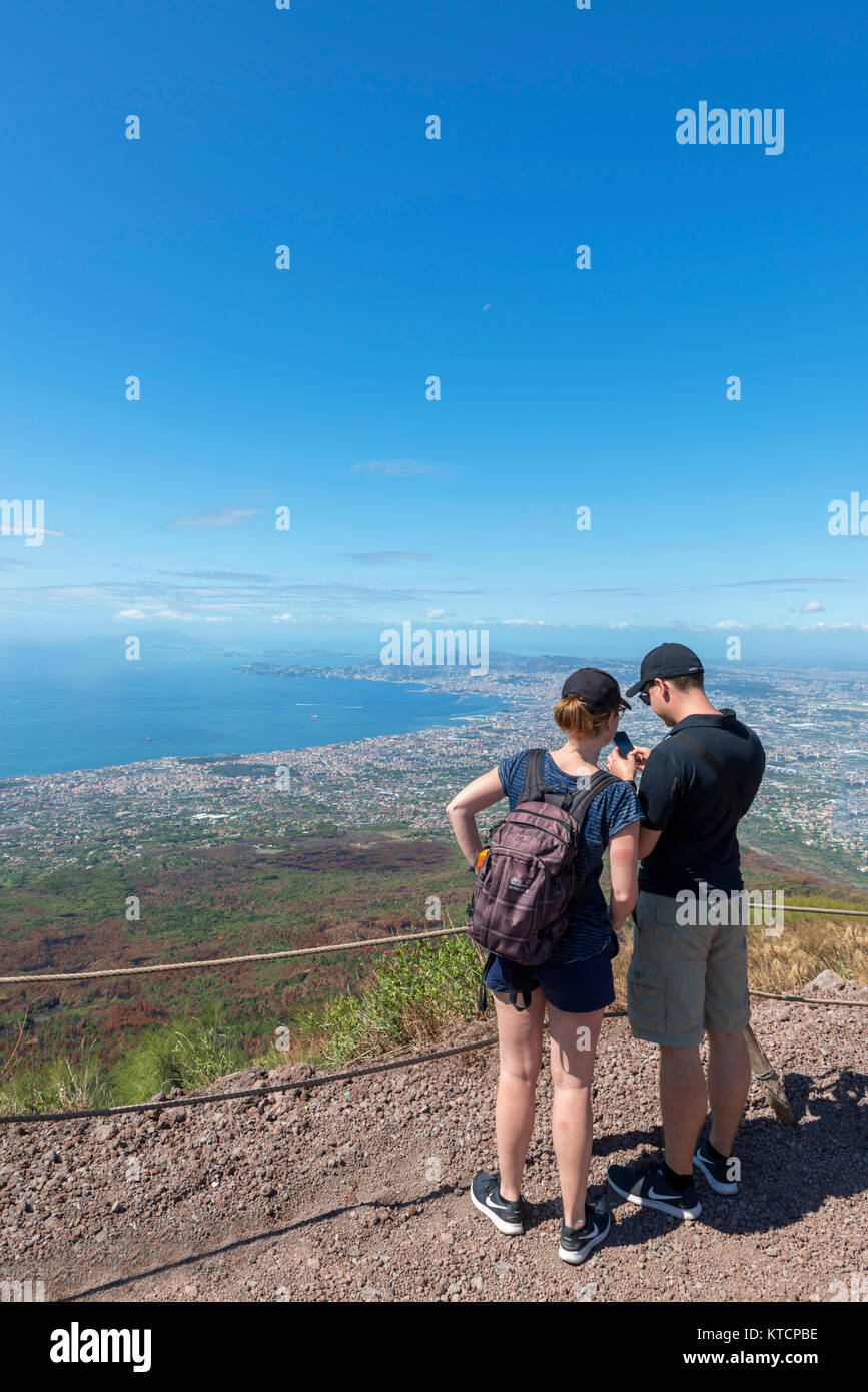 Young couple looking at the view over the city of Naples and the Bay of Naples from the summit of Mount Vesuvius, Naples, Campania,Italy Stock Photo