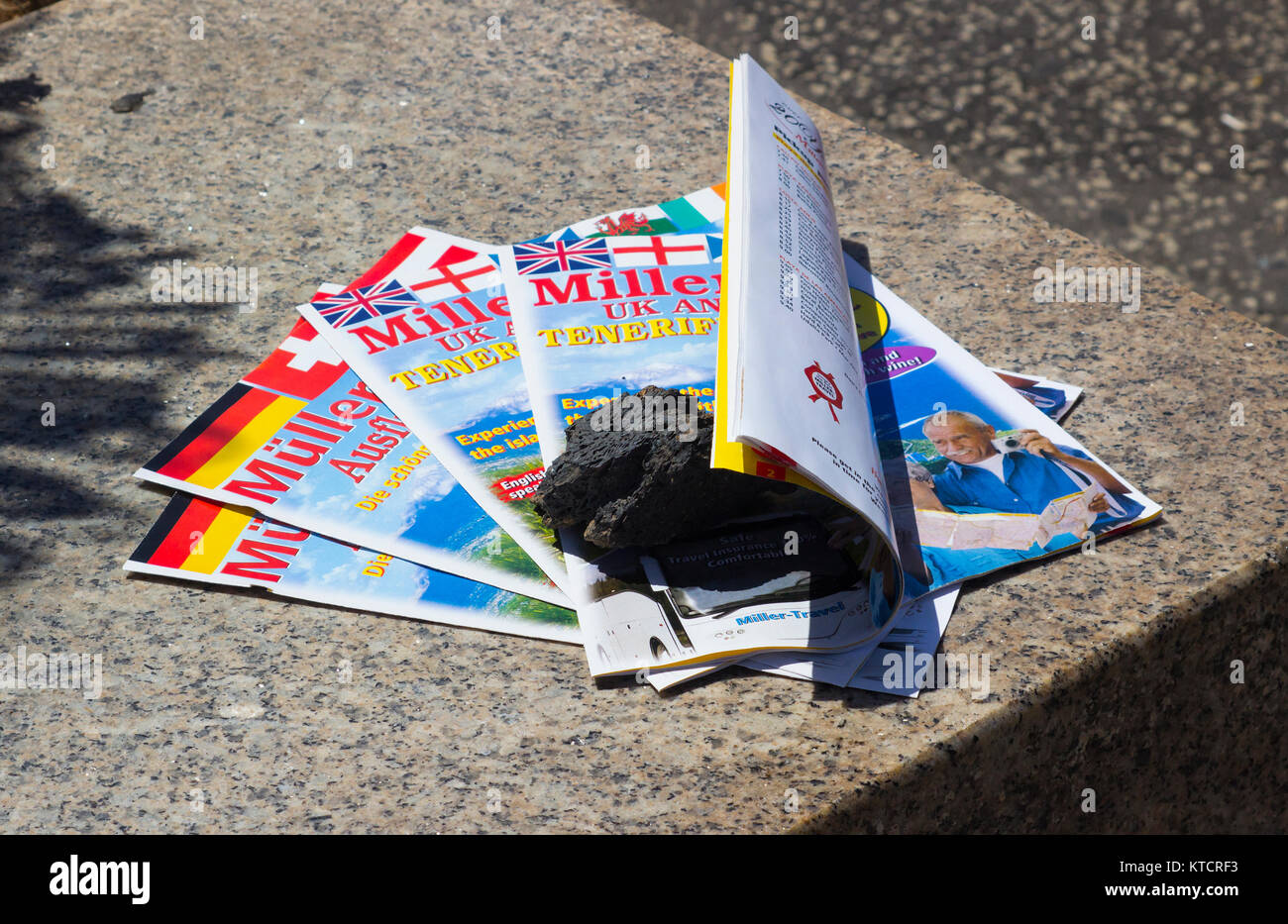 Free to take travel agents brochures laid out on a marble slab in the main street of Playa de las Americas in Tenneriffe Stock Photo