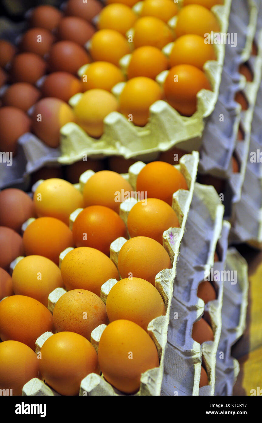 trays of eggs stacked on a market stall in cardboard cartons ready for