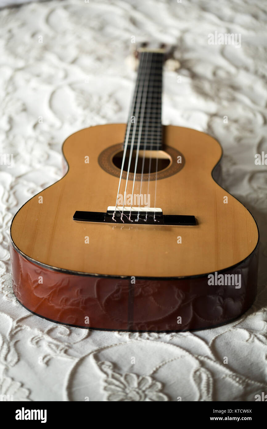 Spanish guitar lying on the bed Stock Photo Alamy