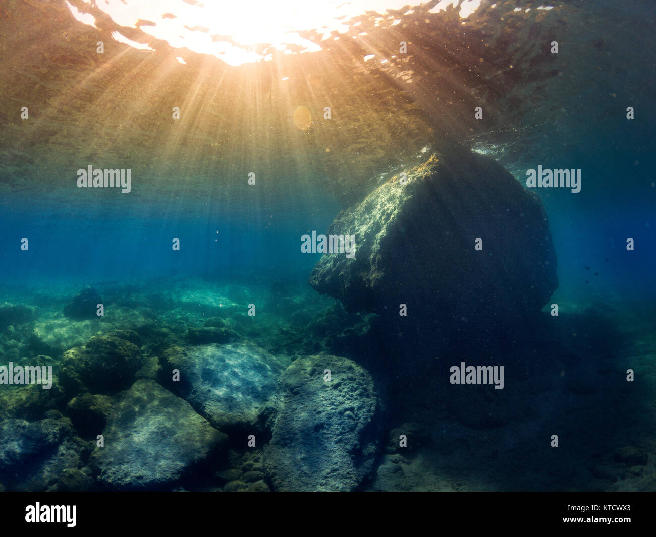 Underwater landscape and a big rock with sunlight rays. Stock Photo