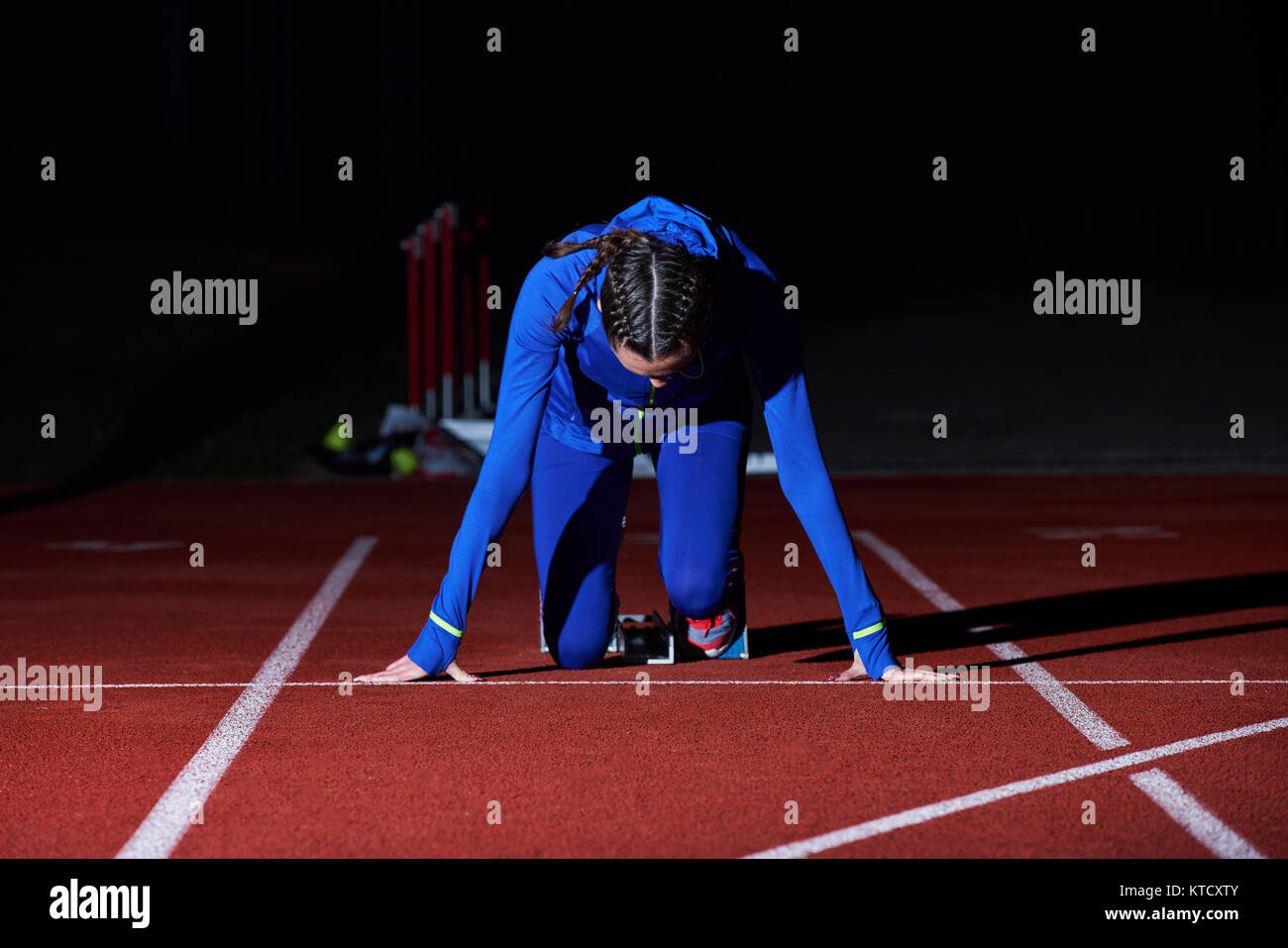 Young female athlete on starting blocks hires stock photography and