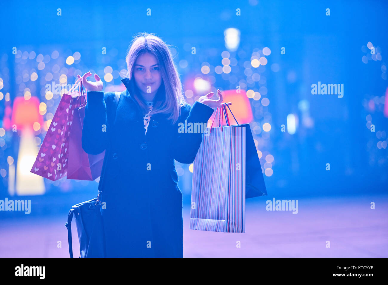 Beautiful woman carrying many shopping bags on a city street Stock