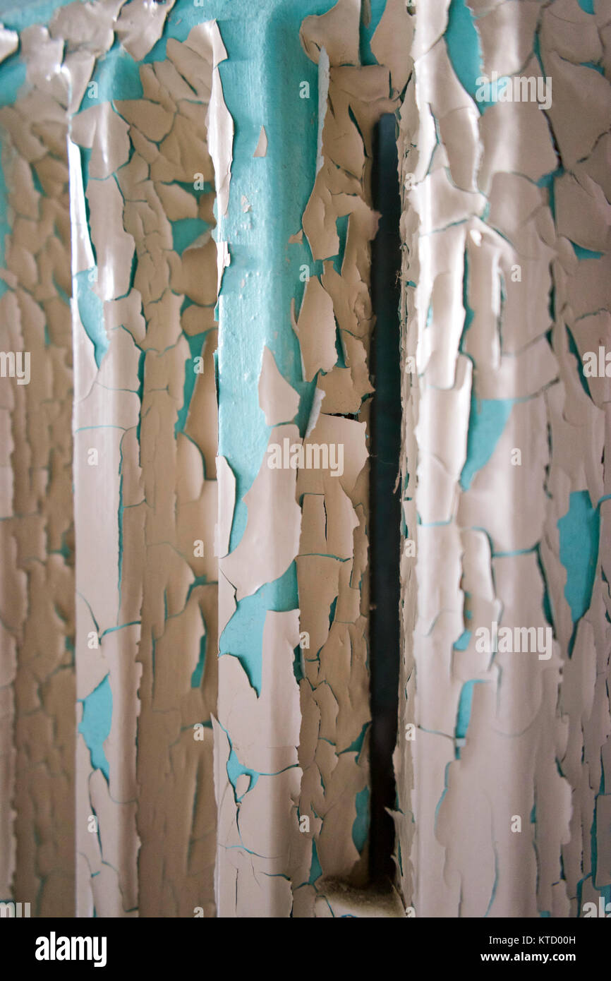 Peeling beige paint revealing the original turquoise base color on an