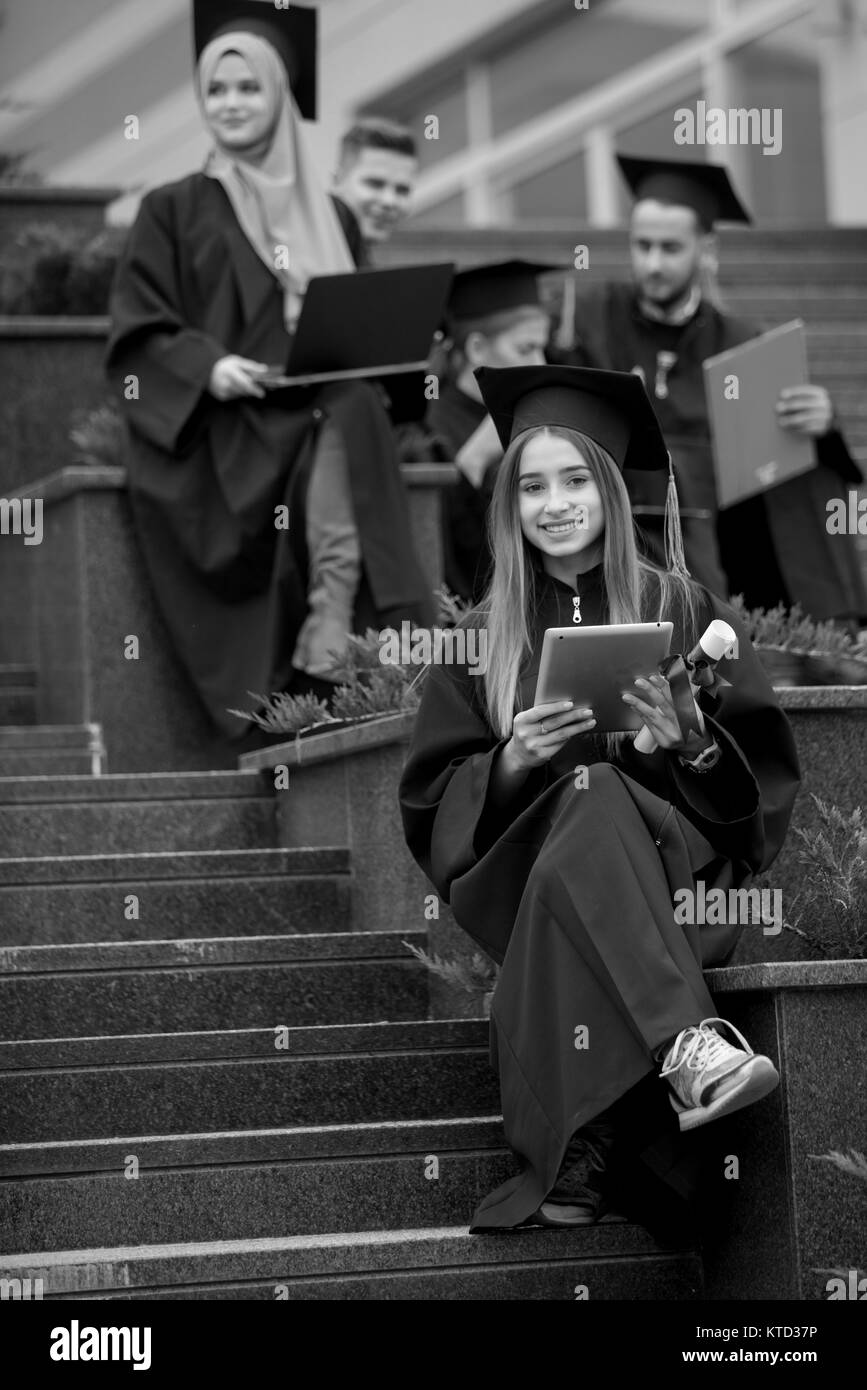 Pretty young graduate with collegues, teamwork, diploma Stock Photo - Alamy