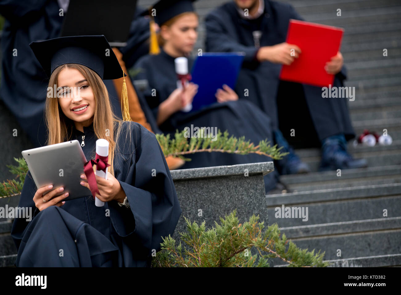 Pretty young graduate with collegues, teamwork, diploma Stock Photo - Alamy