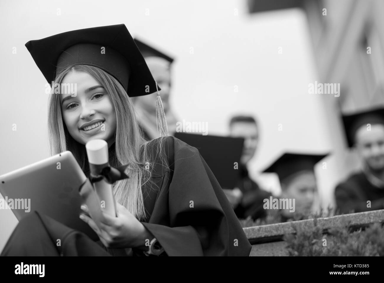 Pretty young graduate with collegues, teamwork, diploma Stock Photo - Alamy