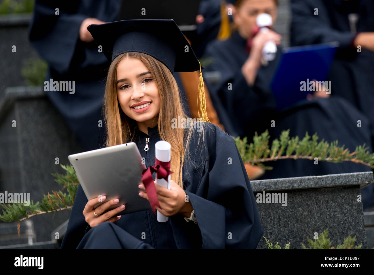 Pretty young graduate with collegues, teamwork, diploma Stock Photo - Alamy