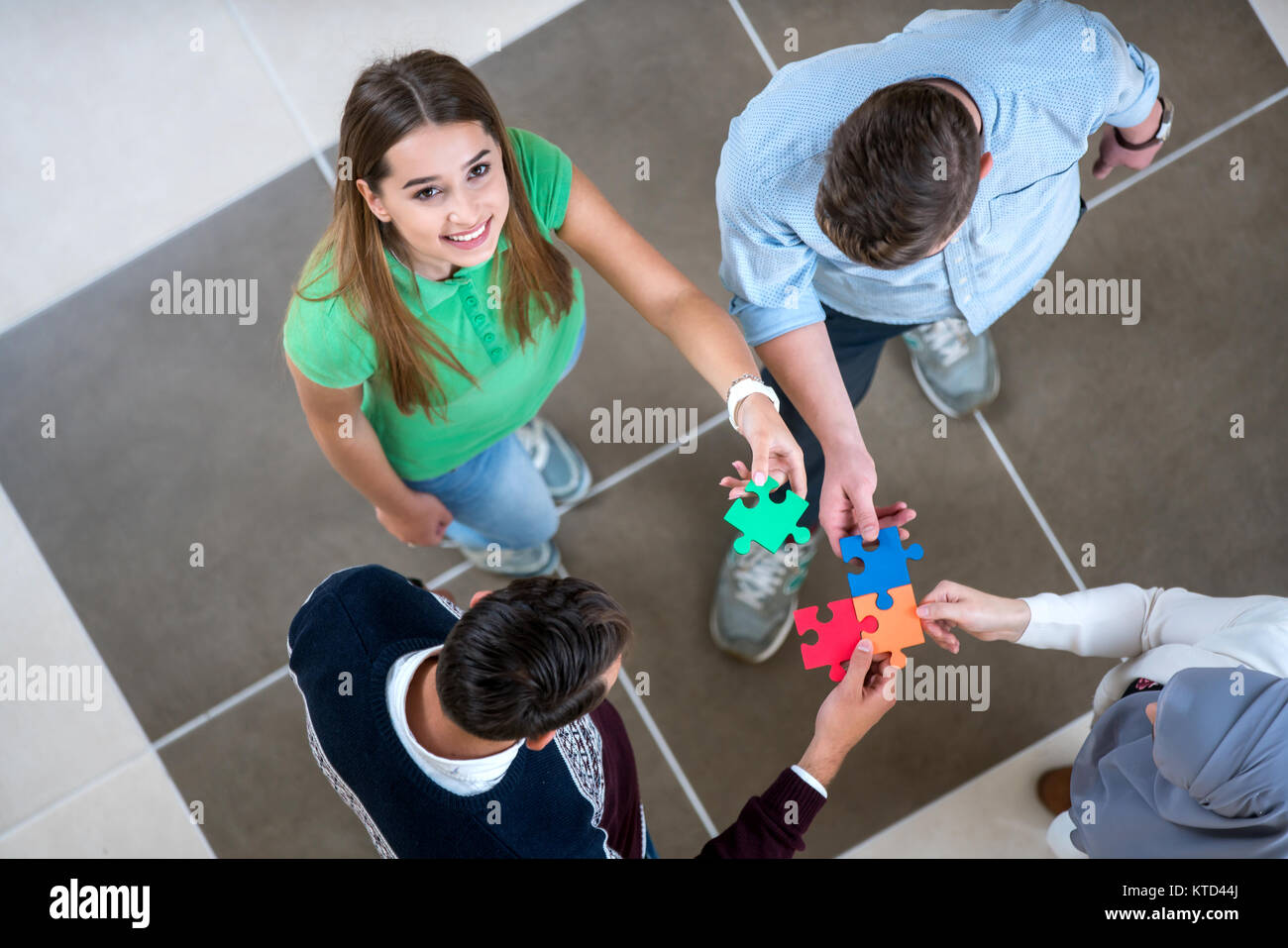 Teamwork of partners. Concept of integration and startup with puzzle pieces, students, work collegues Stock Photo