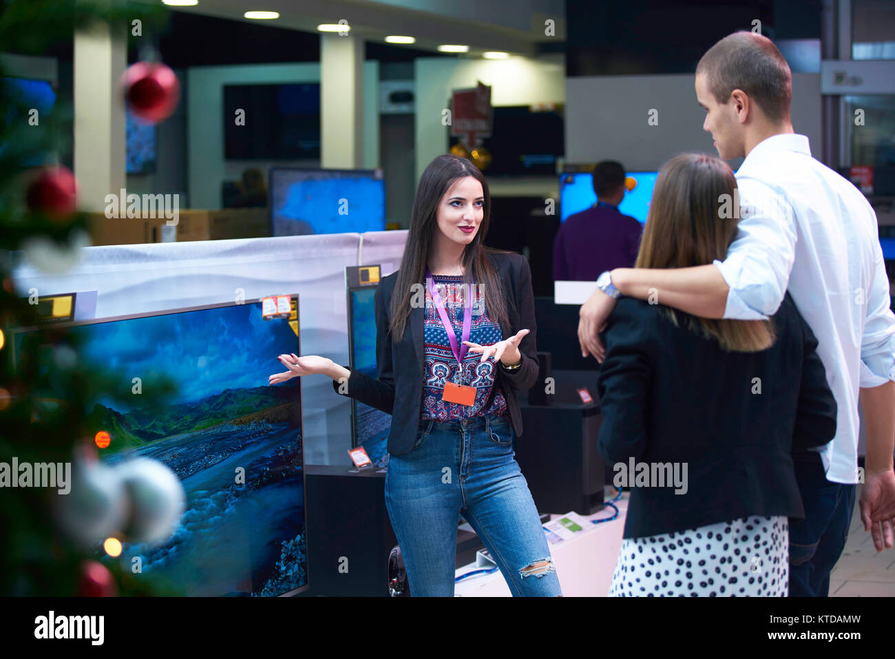 Young couple in consumer electronics store looking at latest laptop, television,mobile and photo camera Stock Photo
