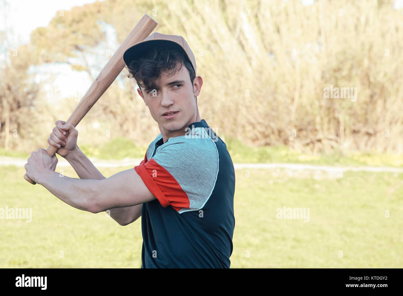 Portrait of young man with baseball bat in park Stock Photo