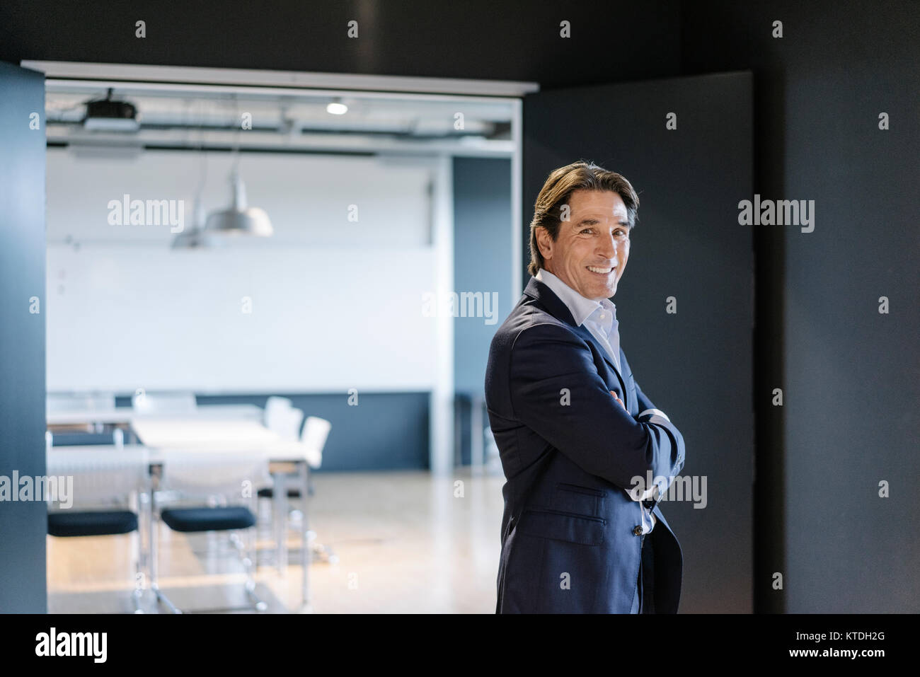 Portrait of smiling businessman standing on office floor Stock Photo ...
