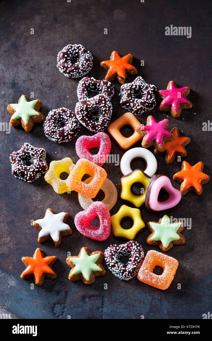 Jelly confectionery, coloured cinnamon stars and other Christmas cookies on dark ground Stock Photo