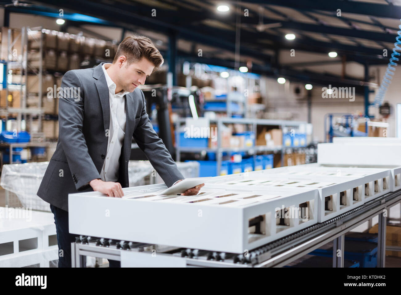 Young manager standing in shop floor reading papers Stock Photo