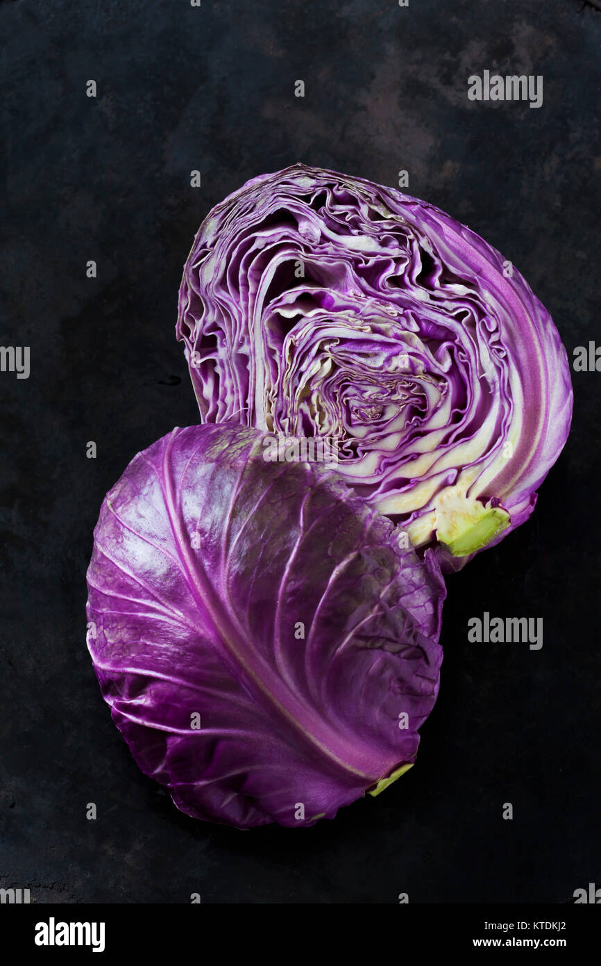 Two halves of purple Sweetheart Cabbage on dark ground Stock Photo