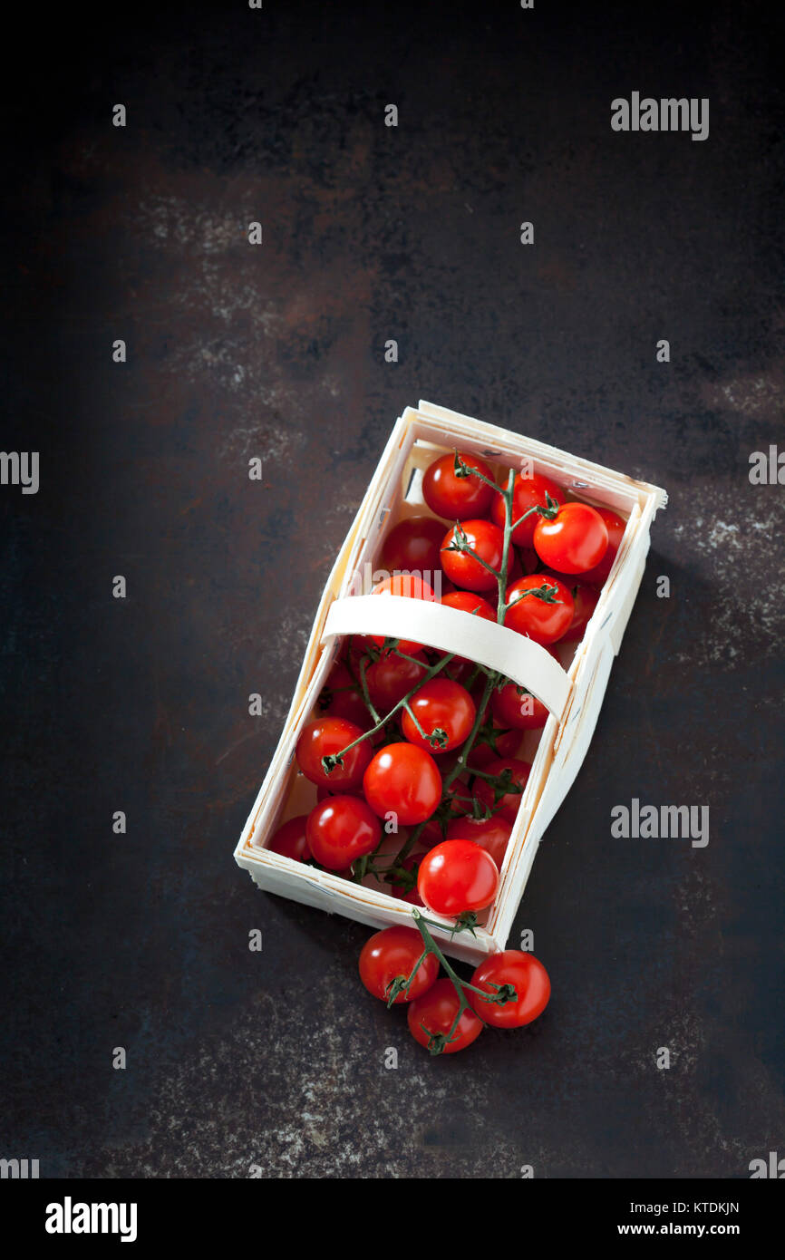 Splint basket of cherry tomatoes on dark grond Stock Photo