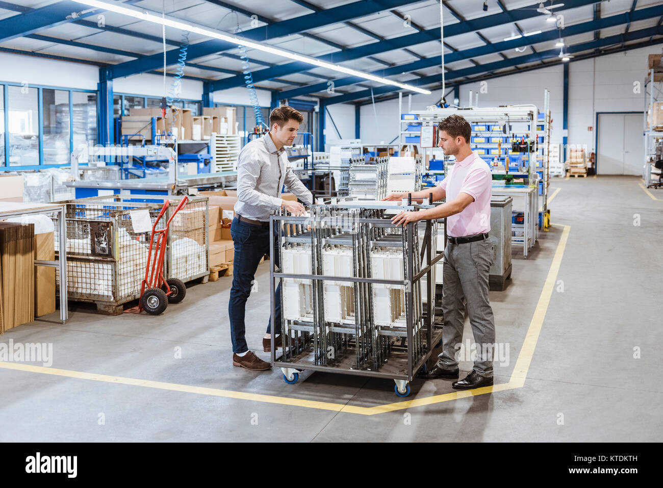 Employees In Shop Floor Checking Product Quality Stock Photo