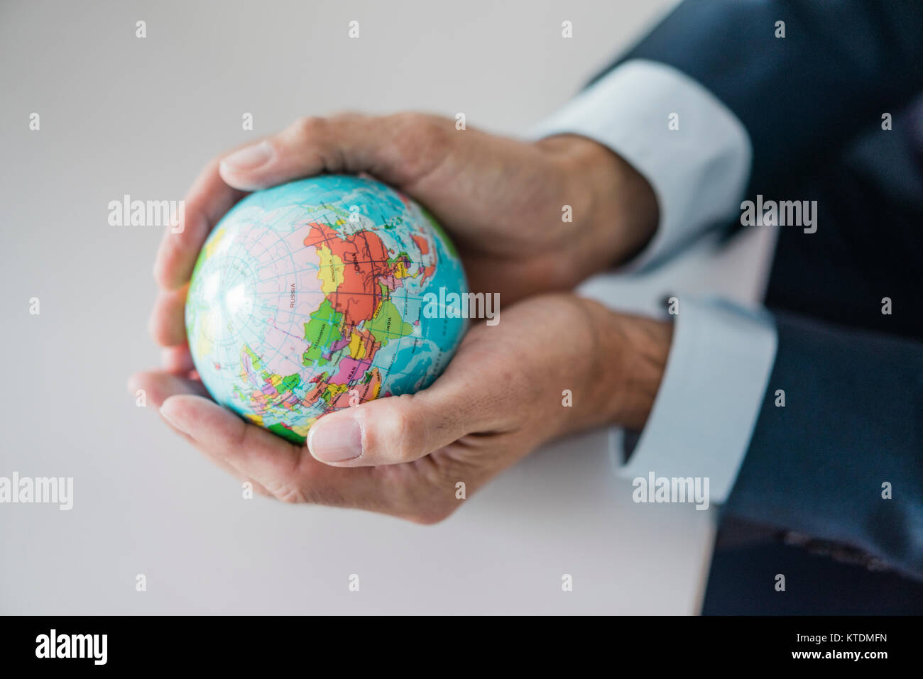 Close-up of hands of businessman holding globe Stock Photo