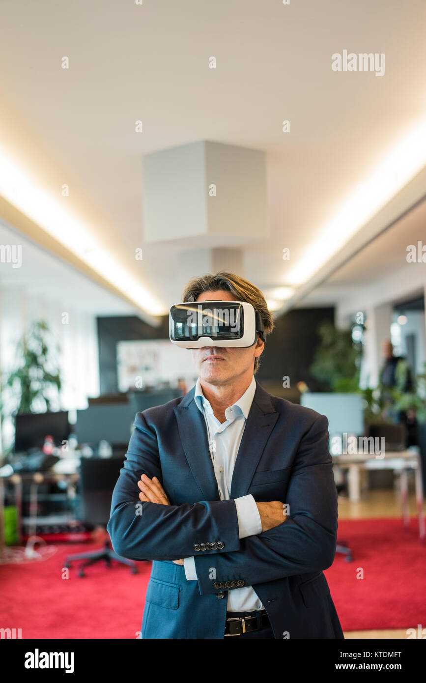 Businessman wearing VR glasses in office Stock Photo - Alamy