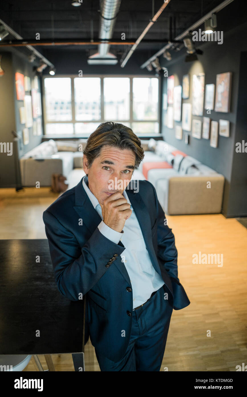 Portrait of businessman standing in office Stock Photo - Alamy