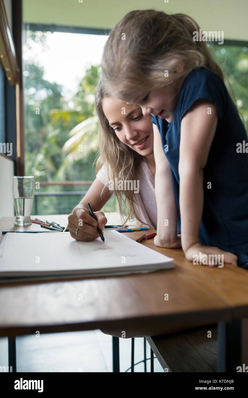 Mother and daughter drawing with crayons Stock Photo
