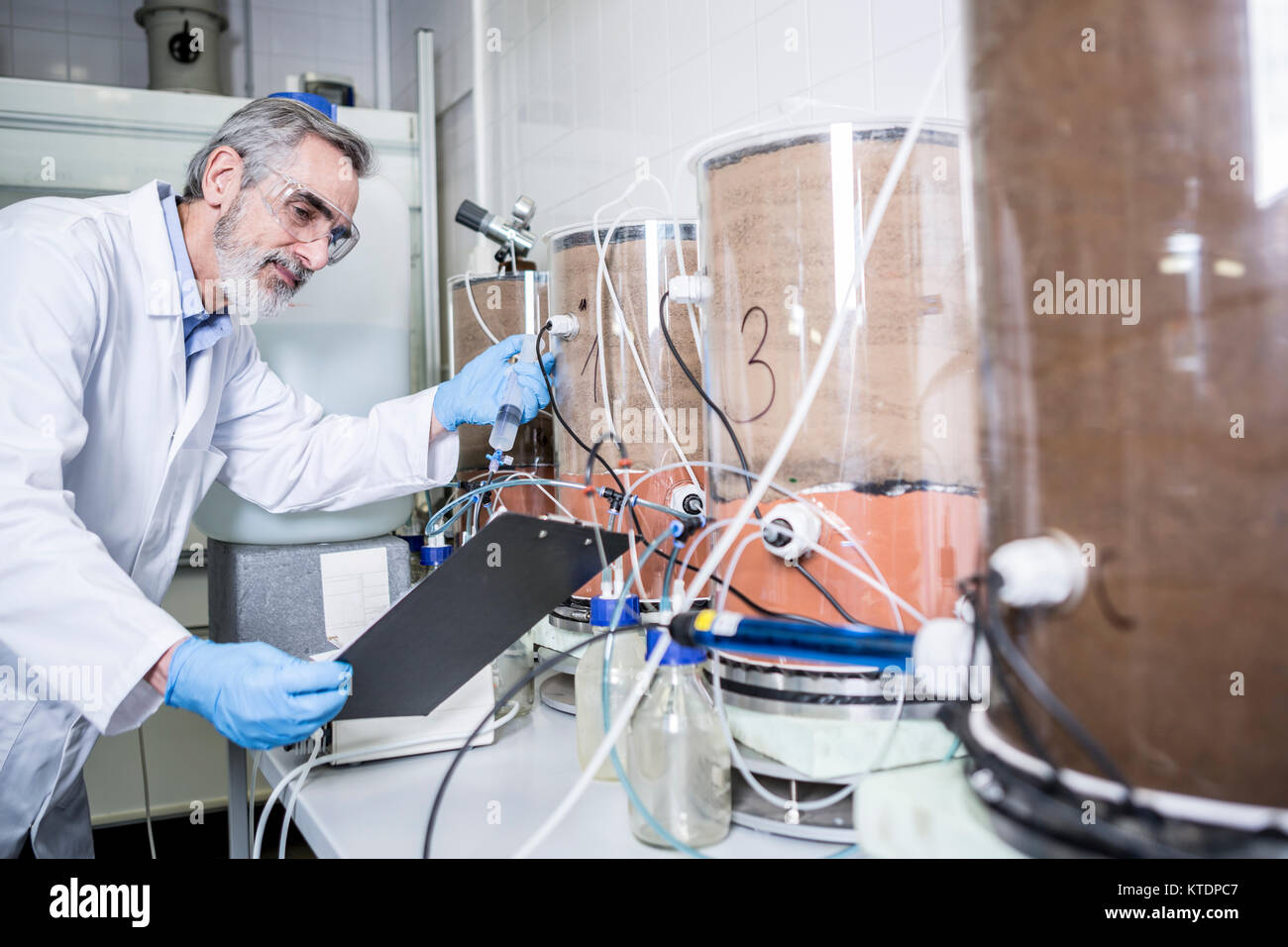 Scientist with clipboard working in lab Stock Photo - Alamy