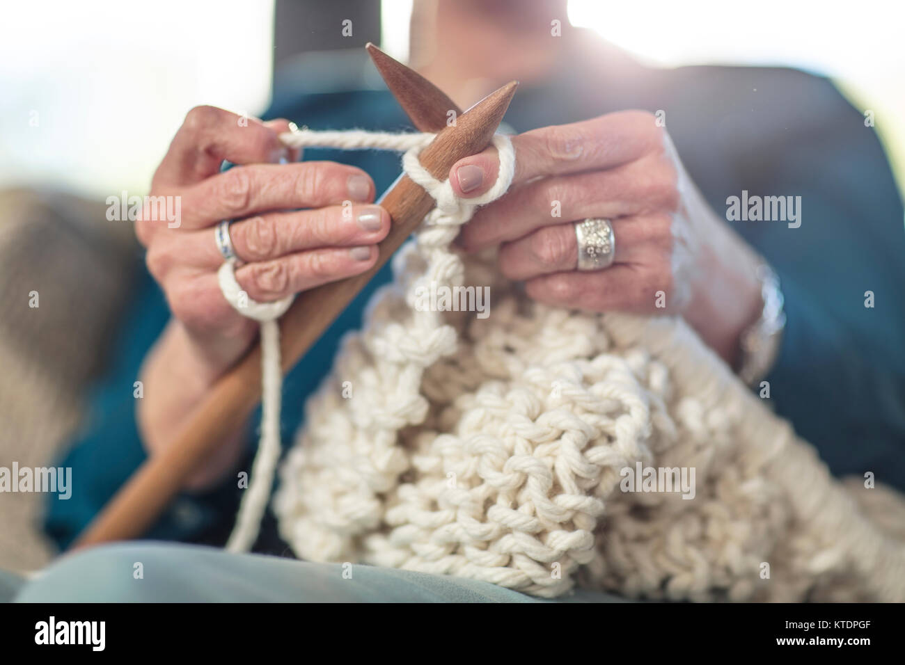 Senior woman knitting on couch at home Stock Photo - Alamy