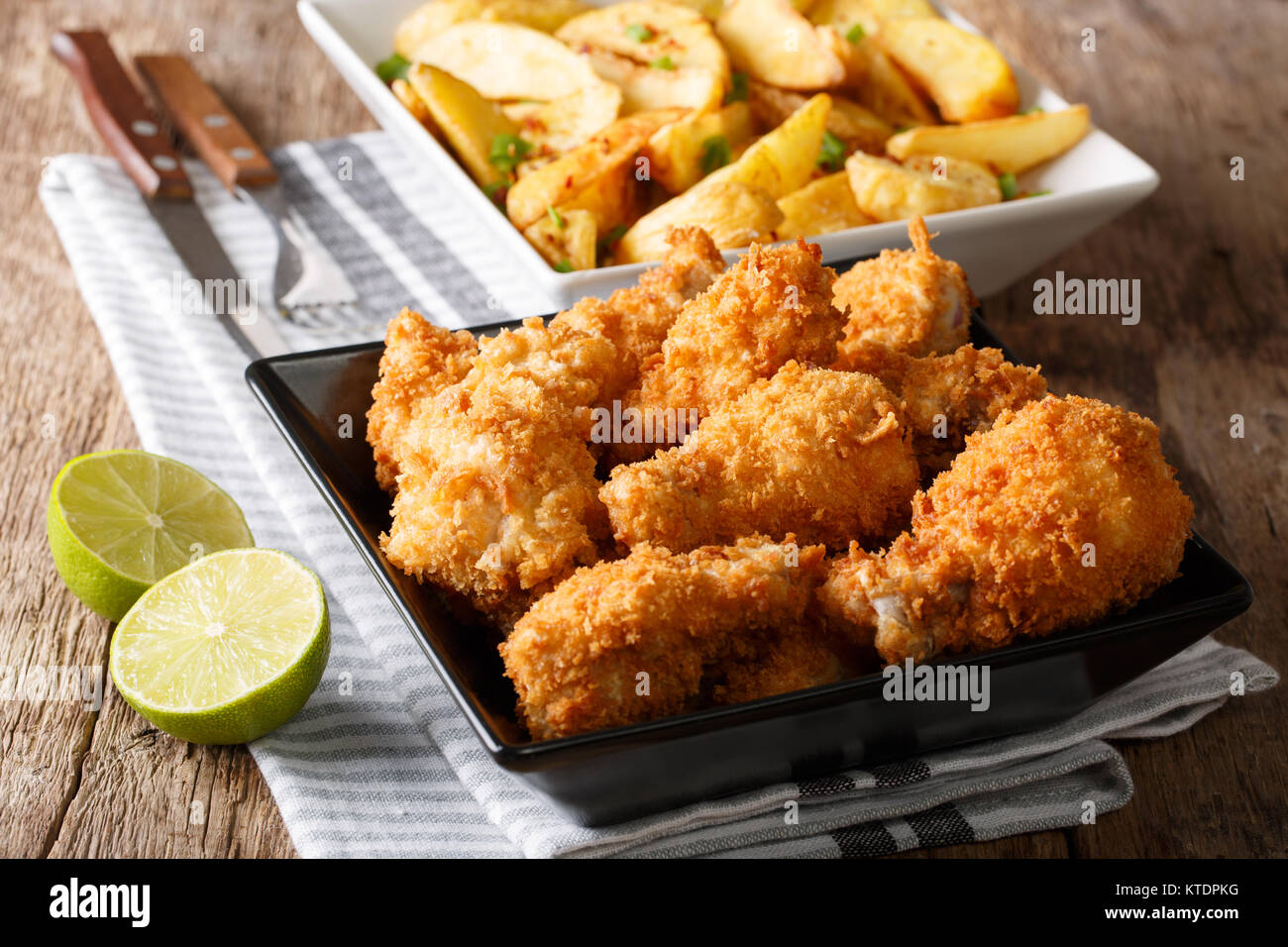 Delicious food: deep-fried chicken wings in breadcrumbs and potato close-up on the table. horizontal Stock Photo