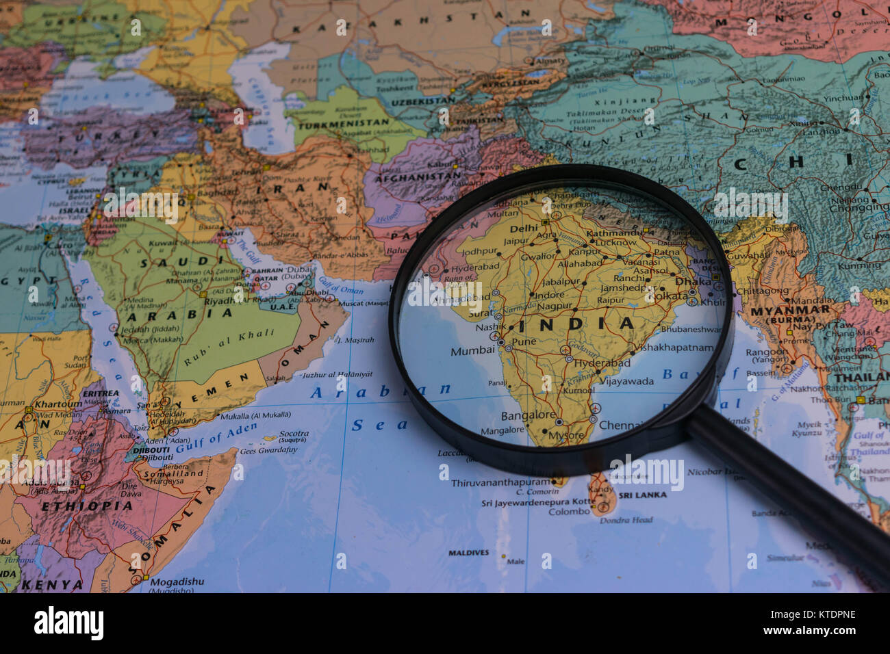 India map through magnifying glass on a world map Stock Photo