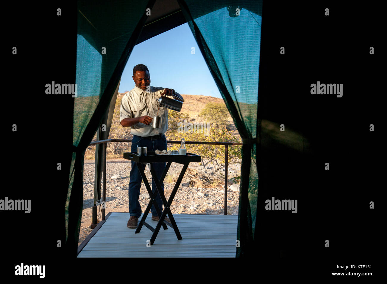 Staff person serving coffee at Huab Under Canvas, Damaraland, Namibia, Africa Stock Photo