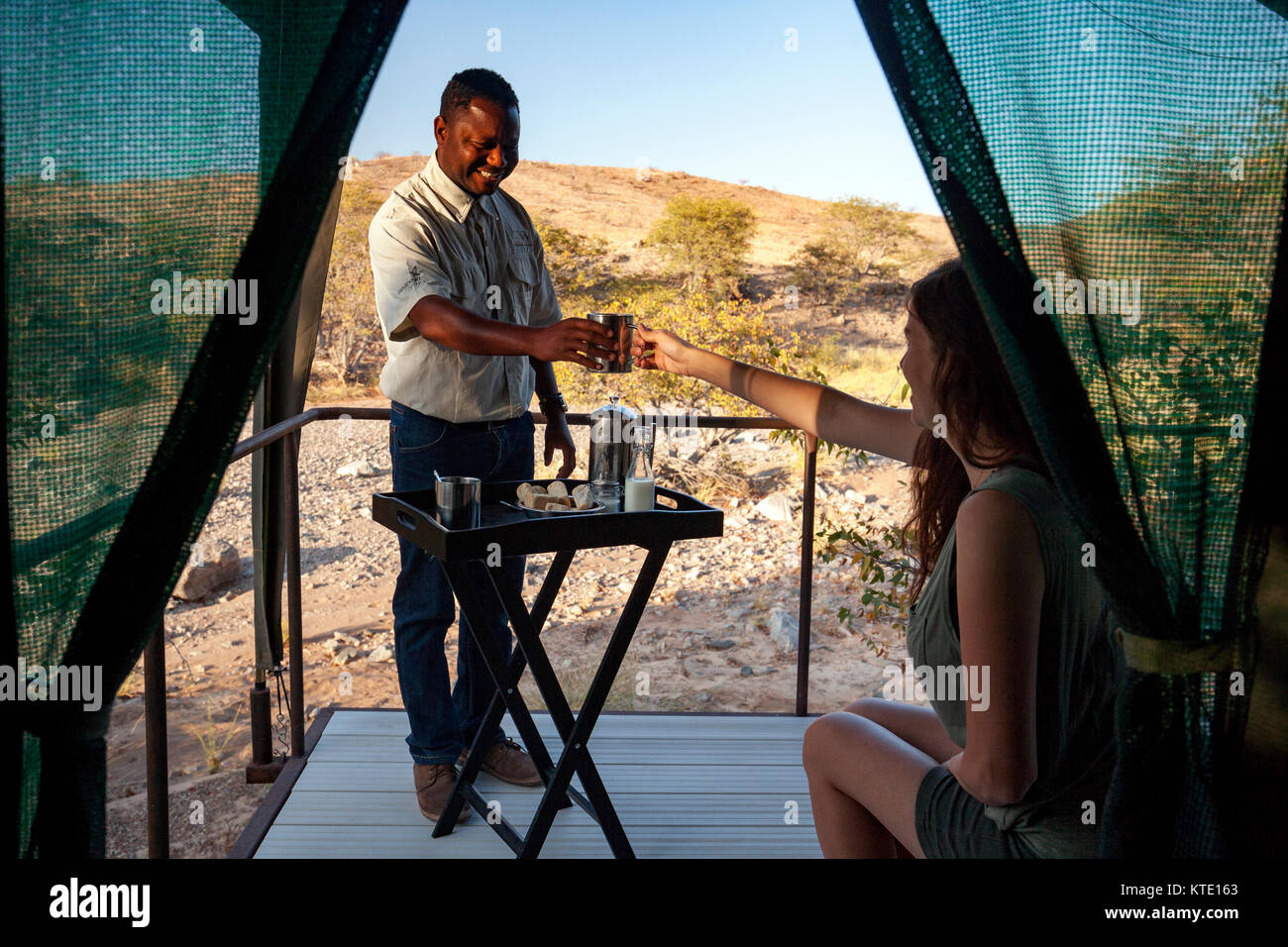 Staff person serving coffee at Huab Under Canvas, Damaraland, Namibia, Africa Stock Photo