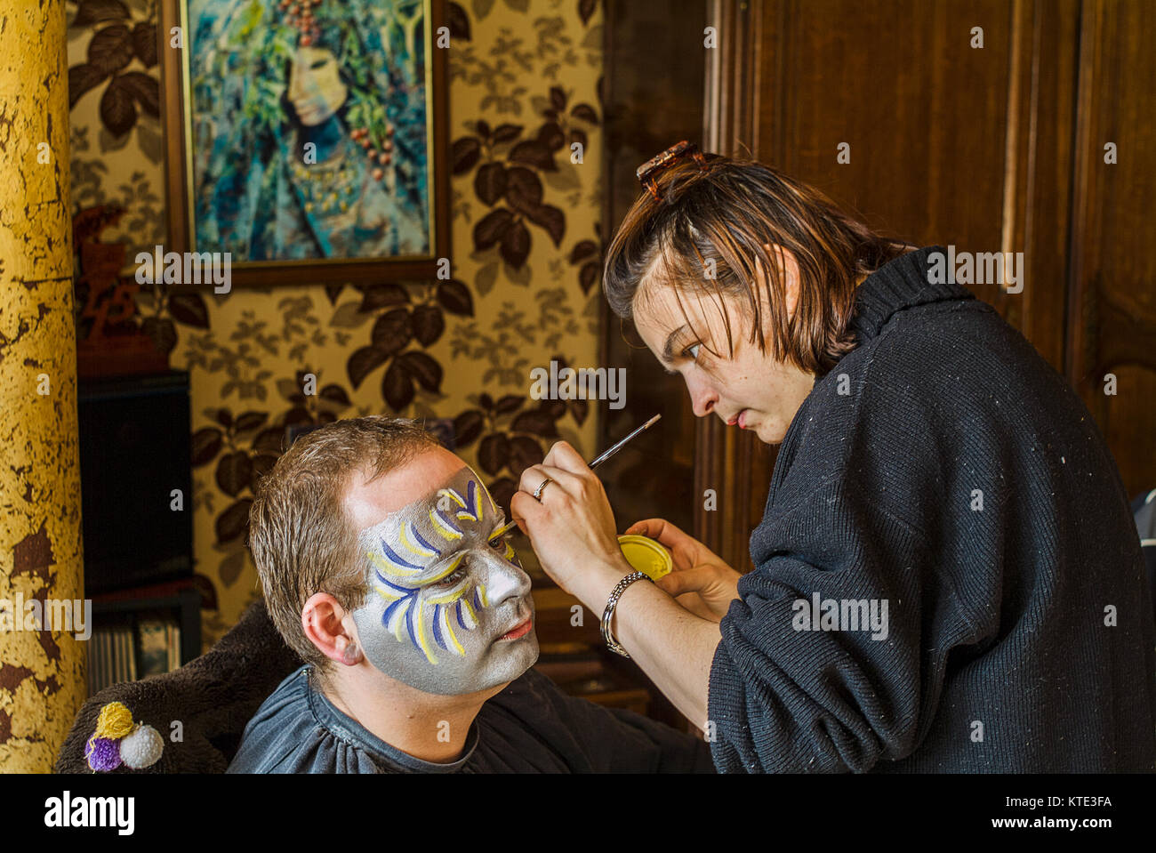 DUNKIRK, France – february 23, 2004 :  Carnival,  men sometimes need the help of their wives to paint their faces Stock Photo