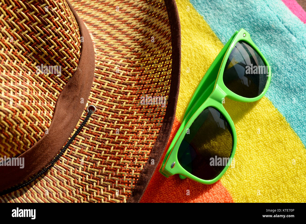 Sun hat with towel and colourful sunglasses Stock Photo