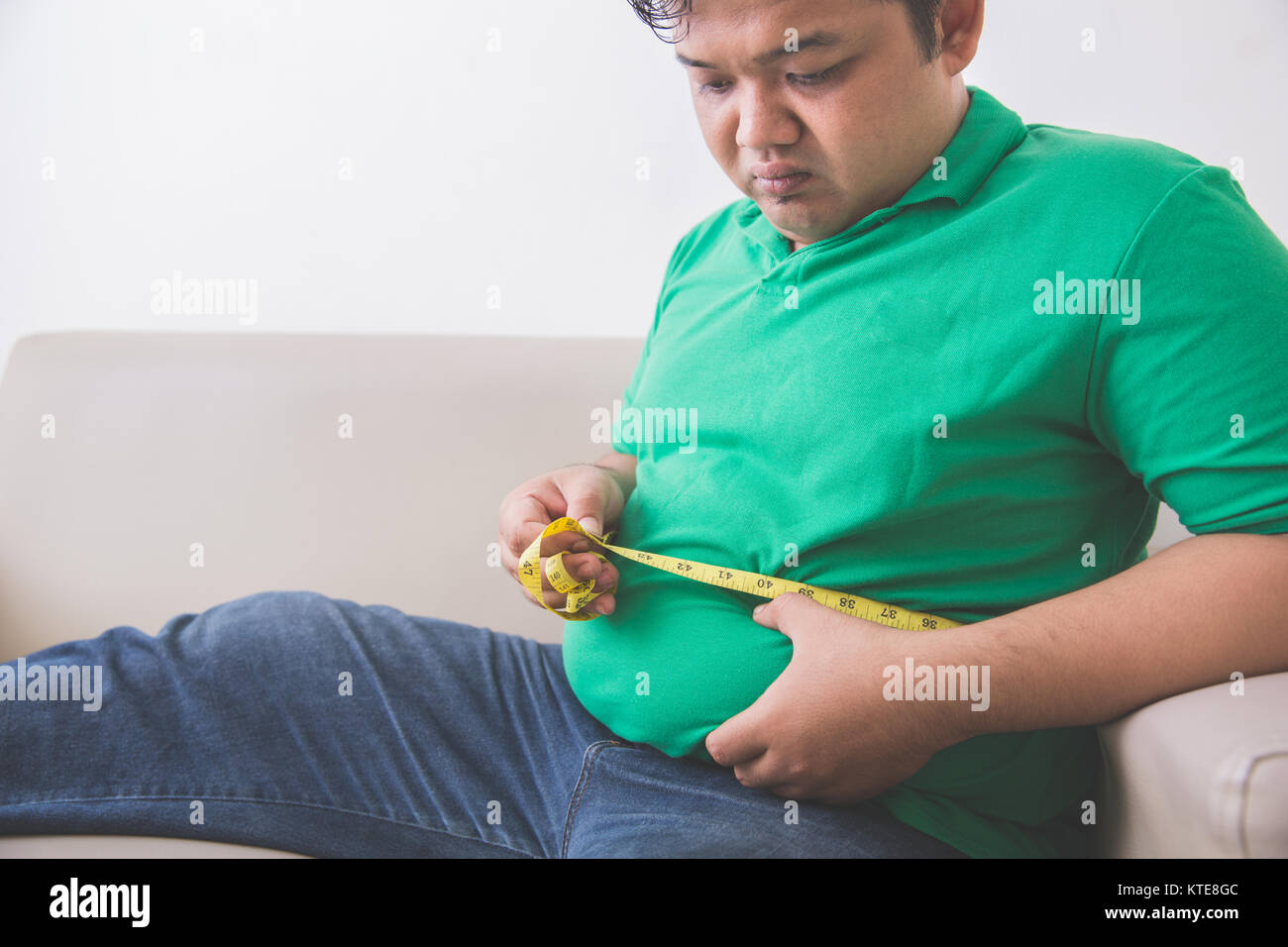 fat man measuring his belly at home Stock Photo - Alamy