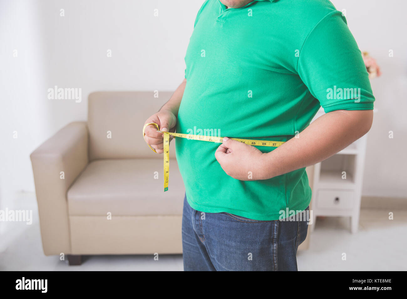 overweight man measuring his belly at home Stock Photo - Alamy