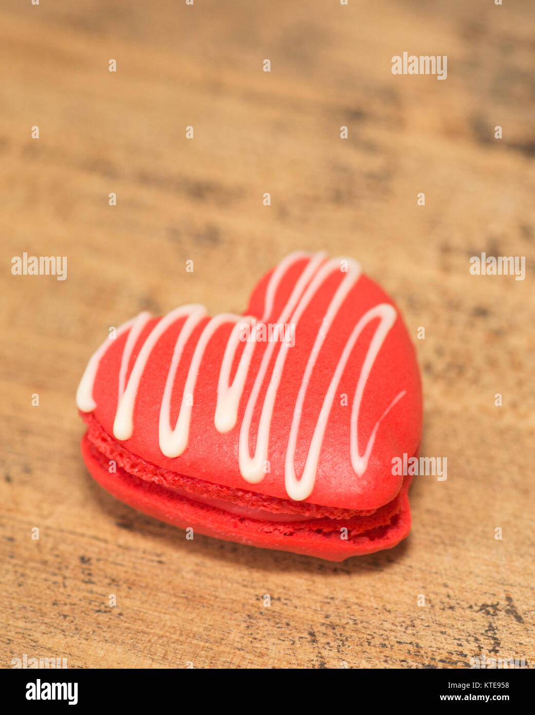 Heart-shaped macaron drizzled with white chocolate Stock Photo