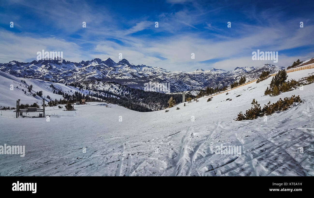 Panoramic view of steep ski trail with snow-covered Sierra Nevada Mountain Range in the background, Mammoth Mountain, Mammoth Lakes, California Stock Photo